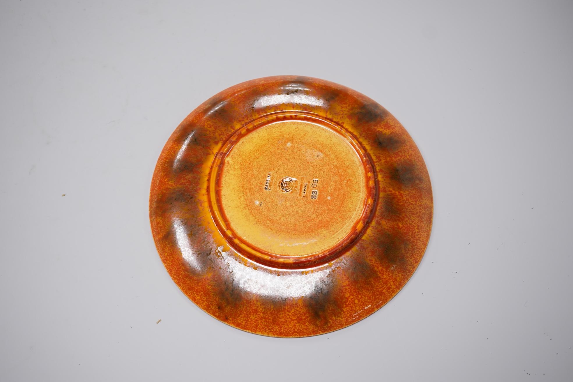 A Pilkingtons orange lustre plate, stamped to the base, 21cm in diameter